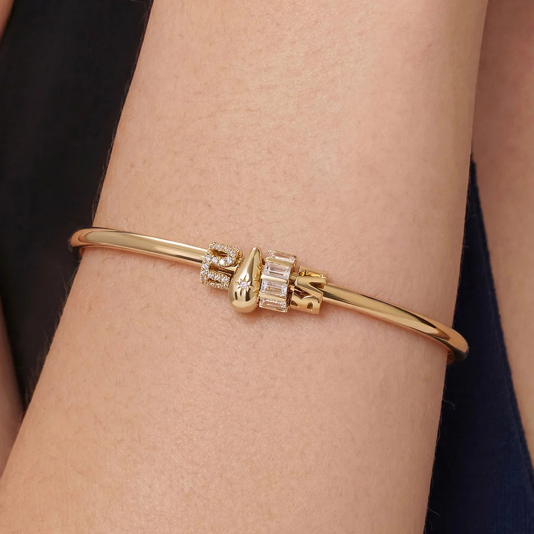 Detalle del charm de diamantes de la pulsera bangle en oro de 14K